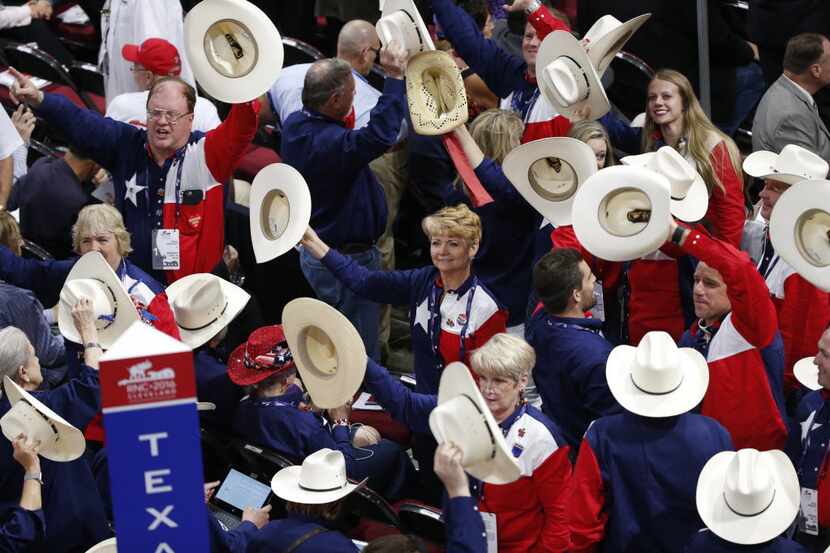 Texas delegates wave their hats to music during the first day of the Republican National...