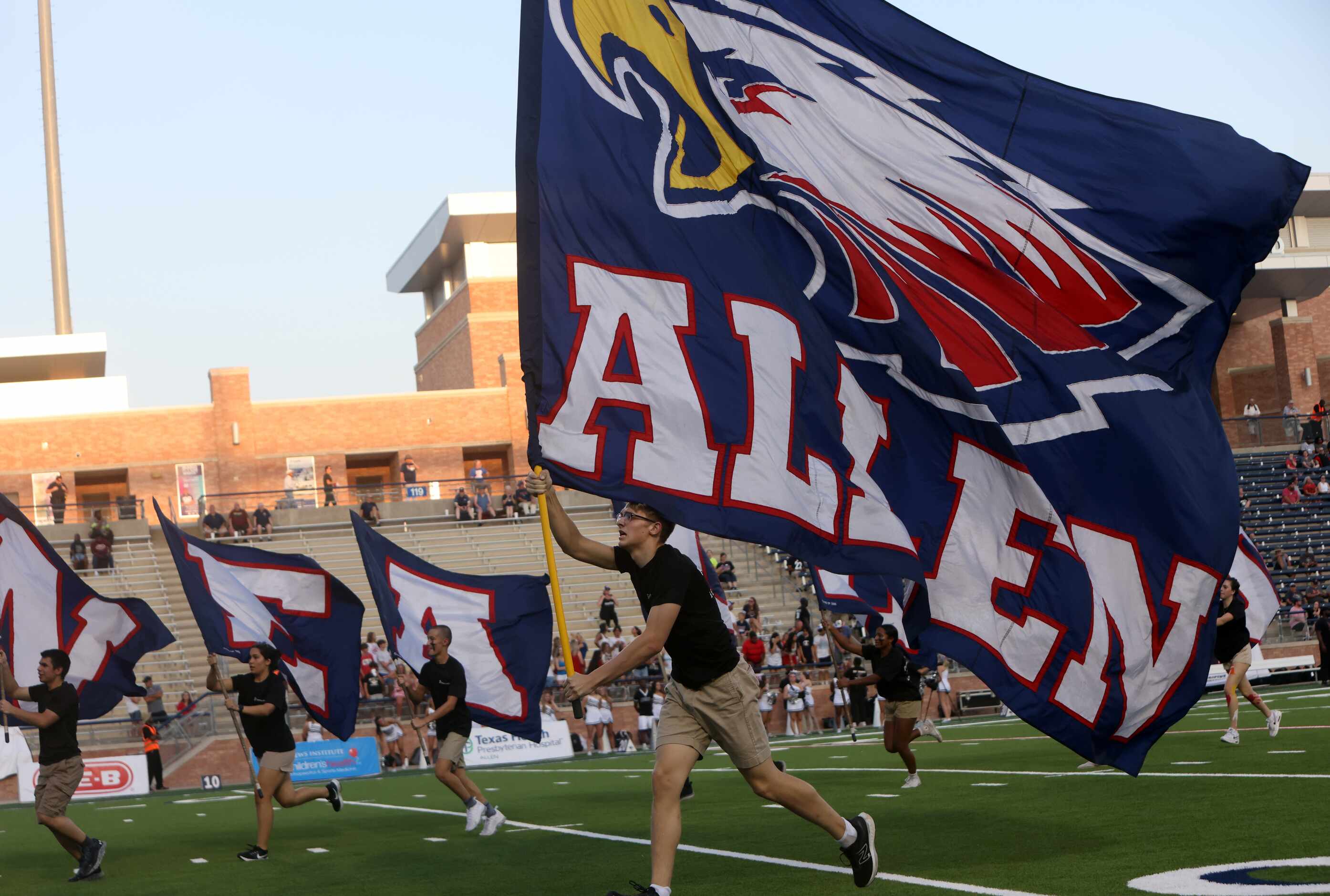 Members of the Allen flag corps run across the field in celebration of an Eagles touchdown...