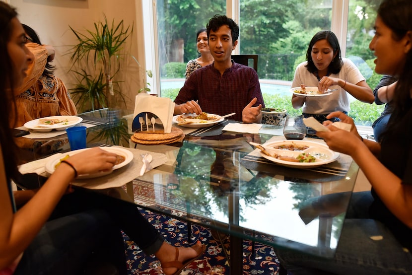 Hirsh Elhence, 24, center, speaks to his sister Meha Elhence, far-left, and cousin Isha...