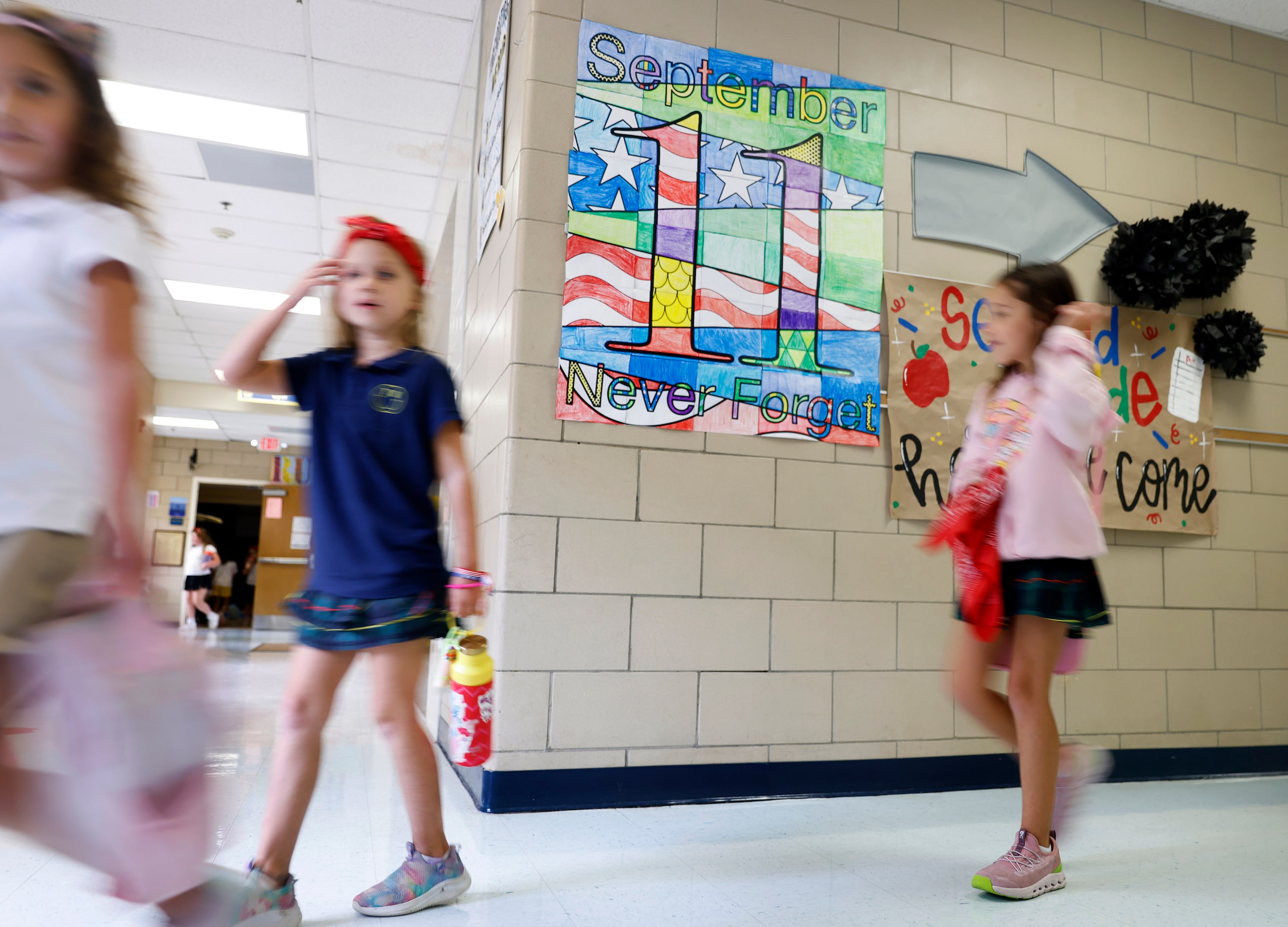 Second graders at Tanglewood Elementary in Fort Worth pass by a colorful reminder of 9/11 as...