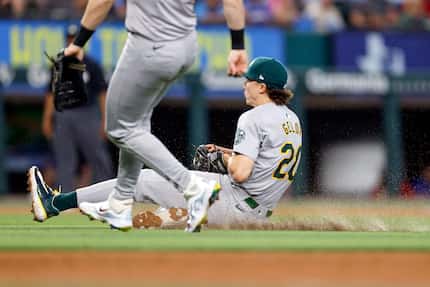 Oakland Athletics second baseman Zack Gelof (20) slides as fails catch a pop fly off the bat...