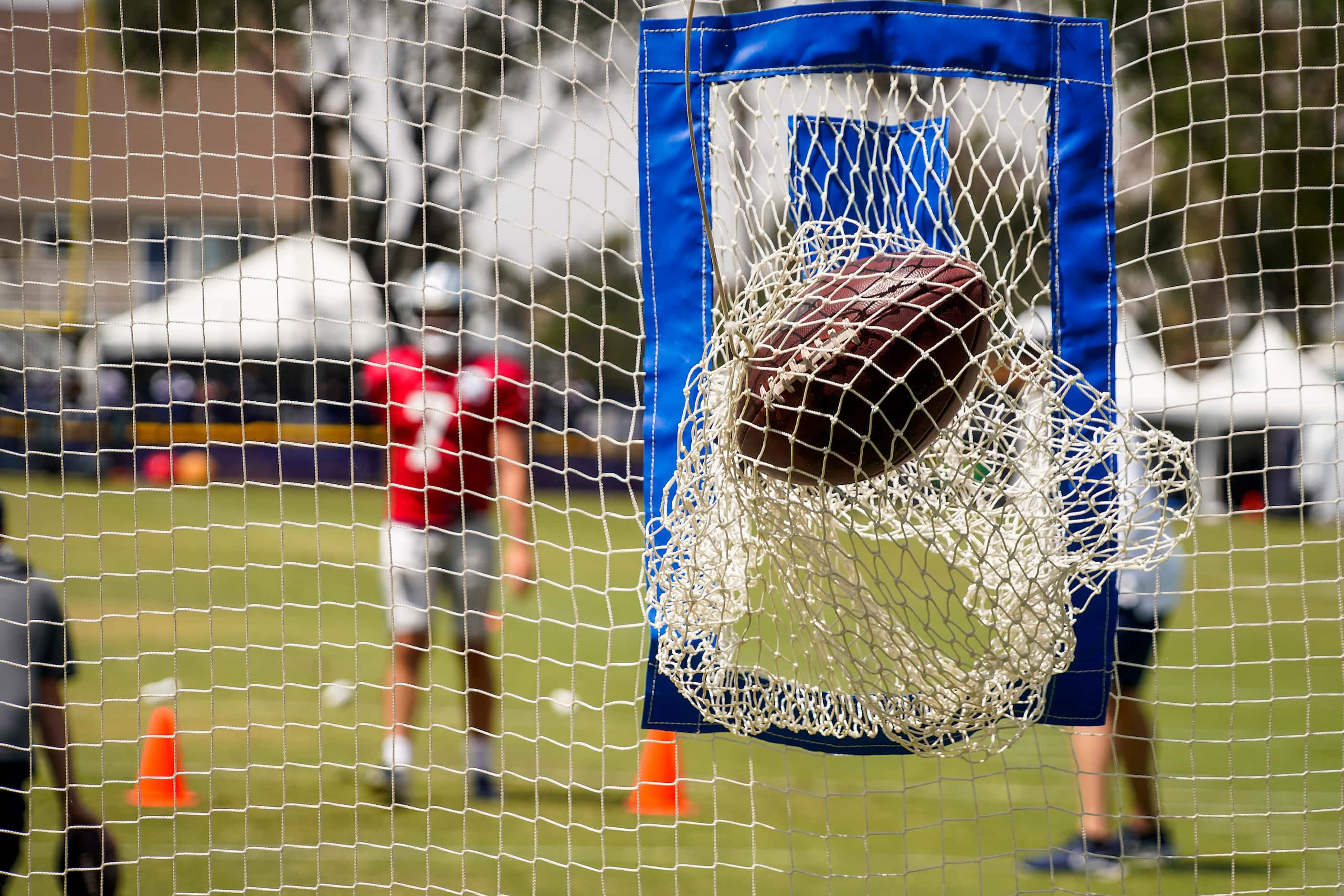 A pass by Dallas Cowboys quarterback Ben DiNucci (7) rips a target net during a practice at...
