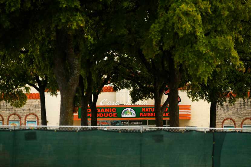 A fence surrounded a small grove of trees in the Casa Linda Plaza shopping center on July...