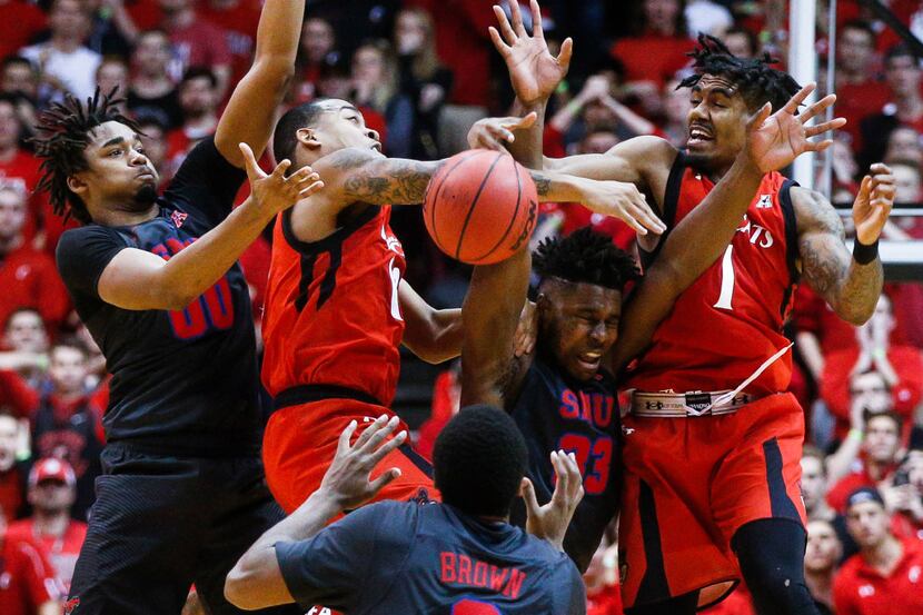 SMU's Ben Moore (00) and Cincinnati's Troy Caupain, second from left, Sterling Brown (3),...