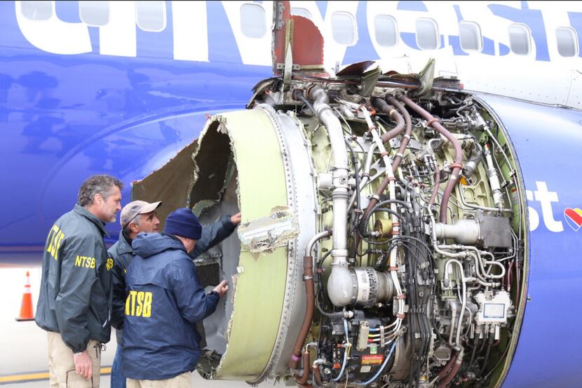 NTSB investigators examine damage to the engine of the Southwest Airlines plane that made an...