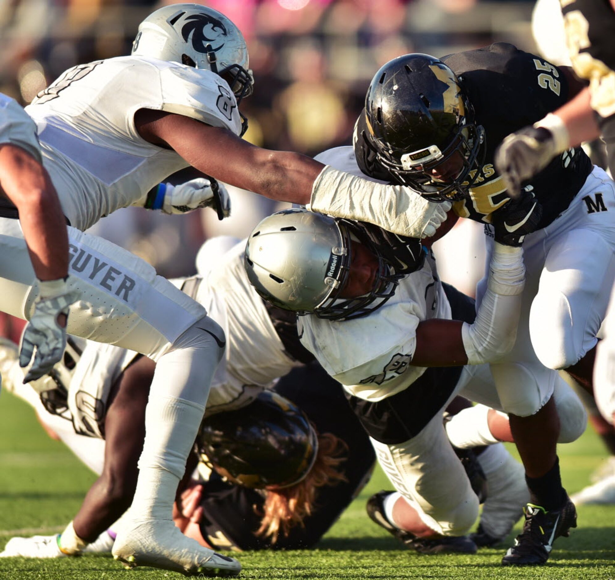 Guyer junior defensive back Bryce Jackson (29) and senior defensive end Tevan McAdams (8)...