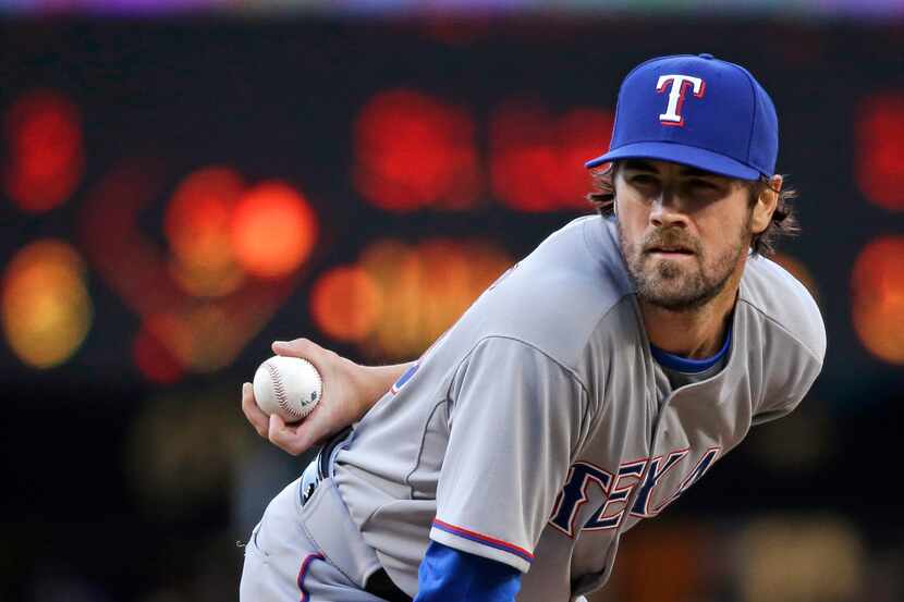 Texas Rangers starting pitcher Cole Hamels looks for a sign as he prepares to throw a pitch...