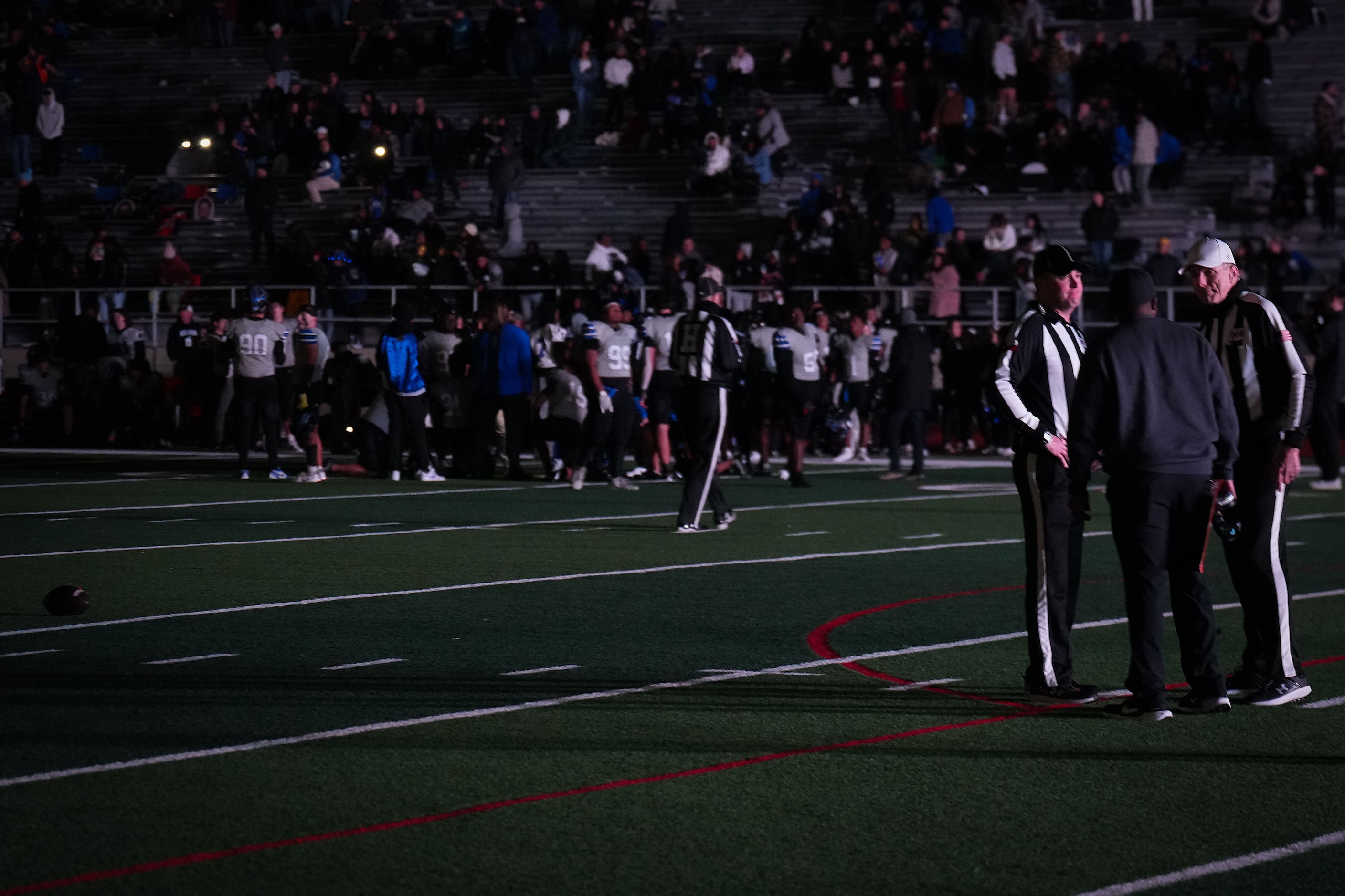 Arlington Bowie head coach Joseph Sam talks with officials on a darkened field during a...