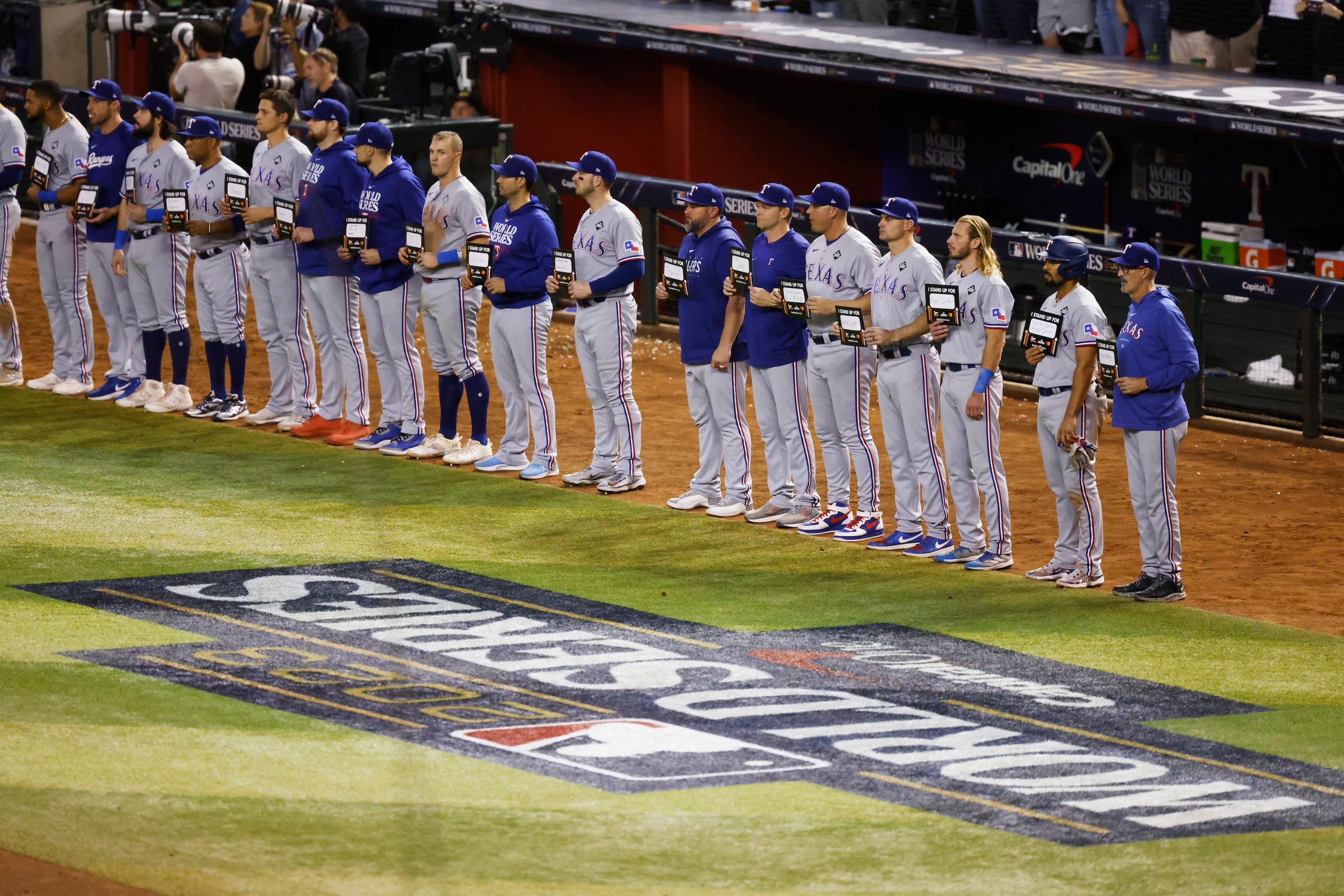 Texas Rangers players hold up Stand Up to Cancer signs after the fifth inning in Game 4 of...