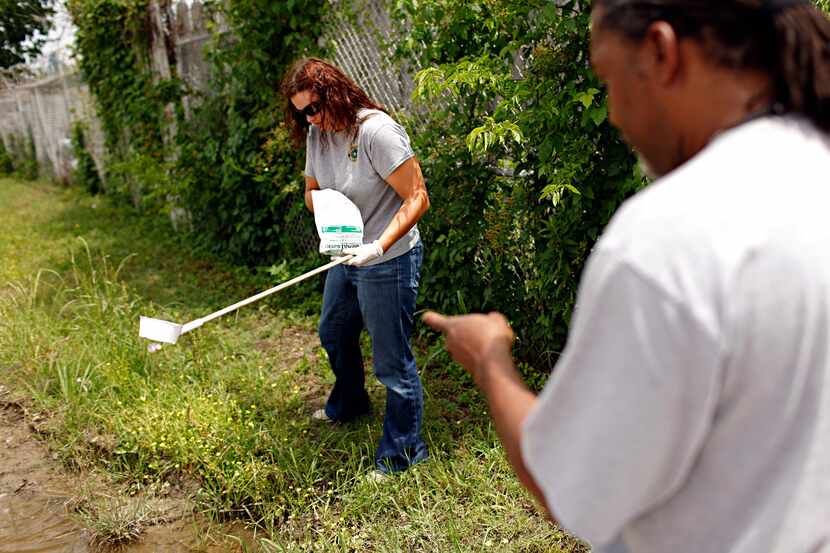Byron Chism (right), a mosquito technician with Dallas County, points out spots to...