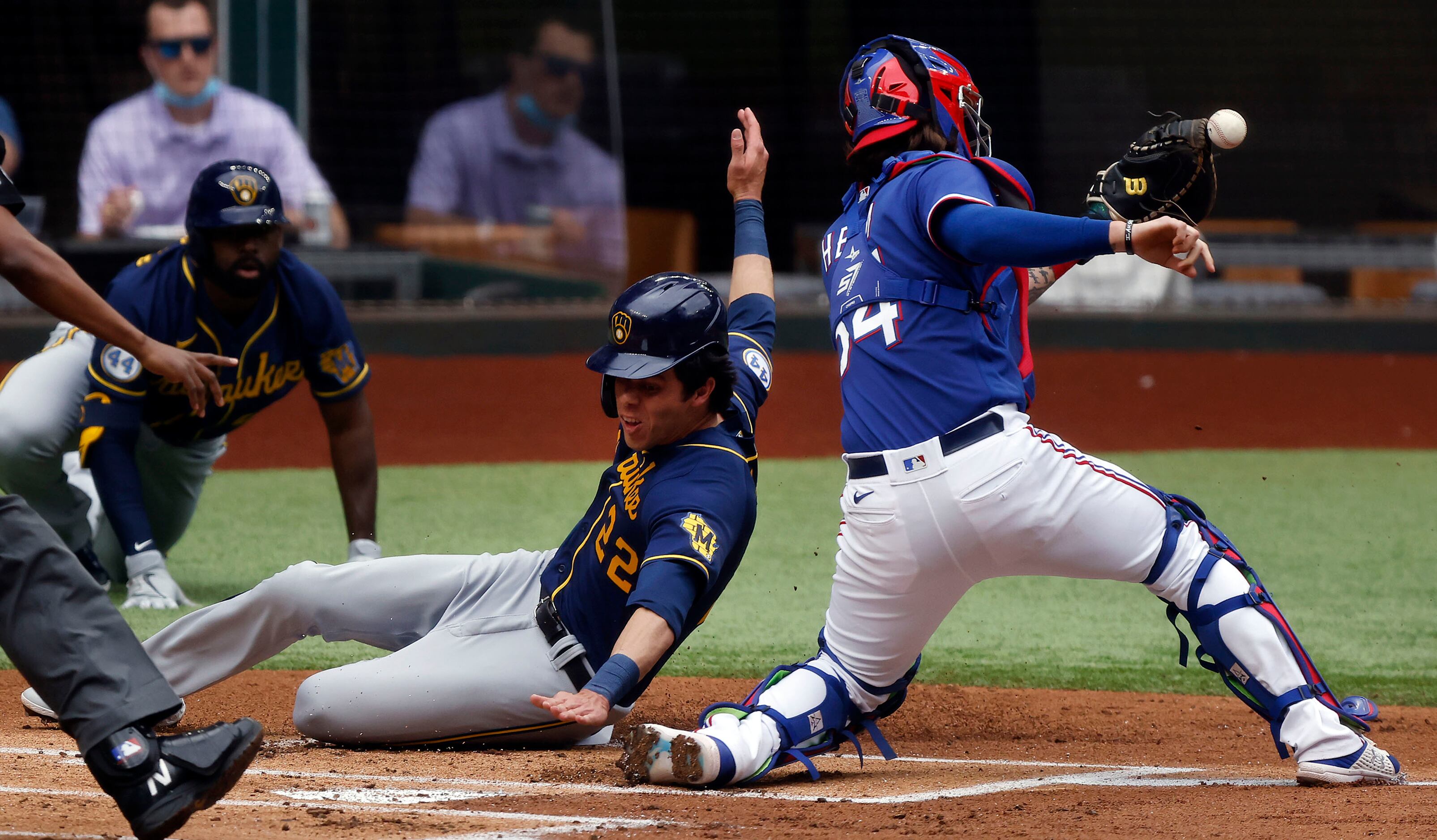 Milwaukee Brewers Christian Yelich (22) slides safely into home plate as Texas Rangers...