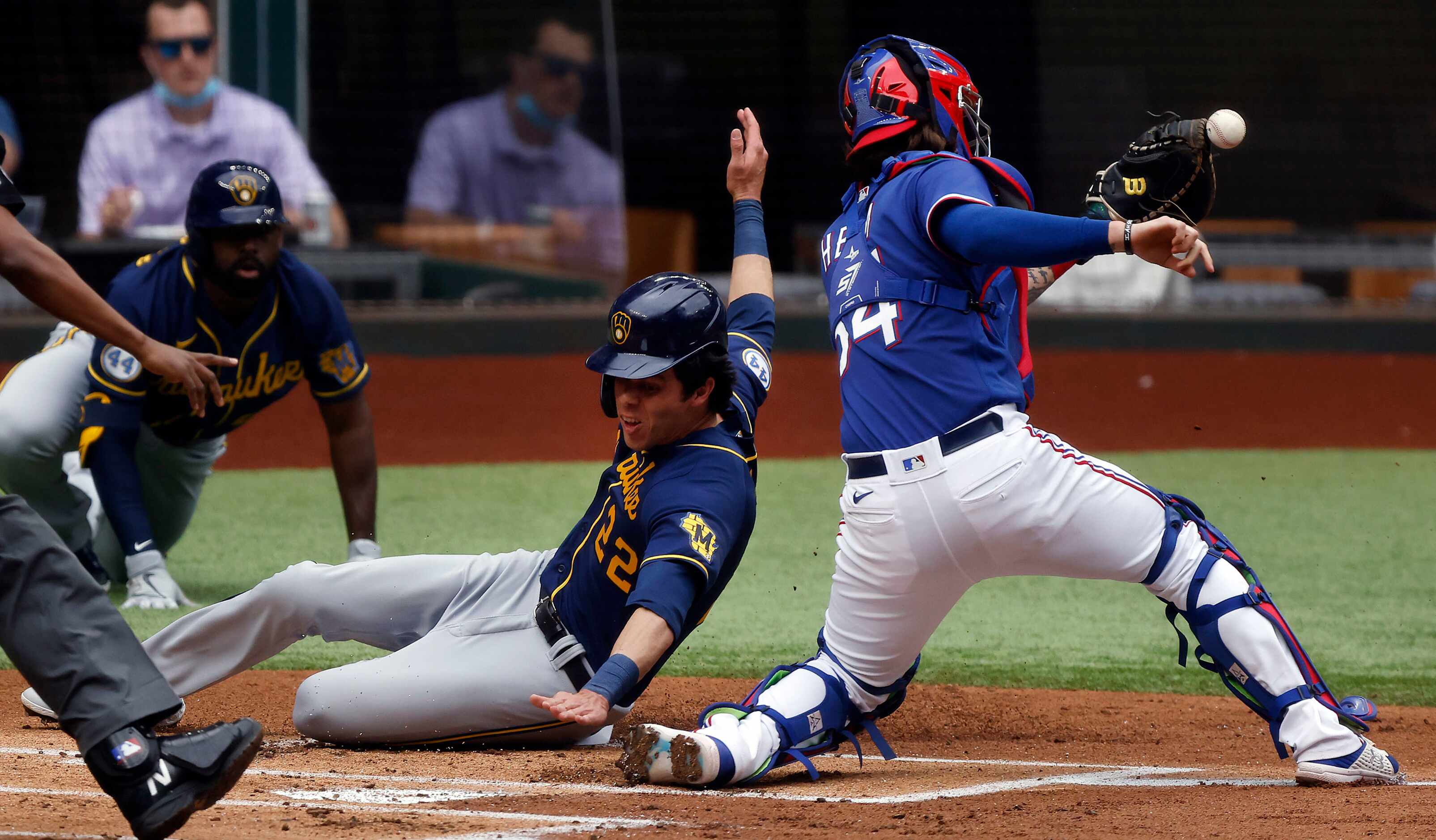 Milwaukee Brewers Christian Yelich (22) slides safely into home plate as Texas Rangers...