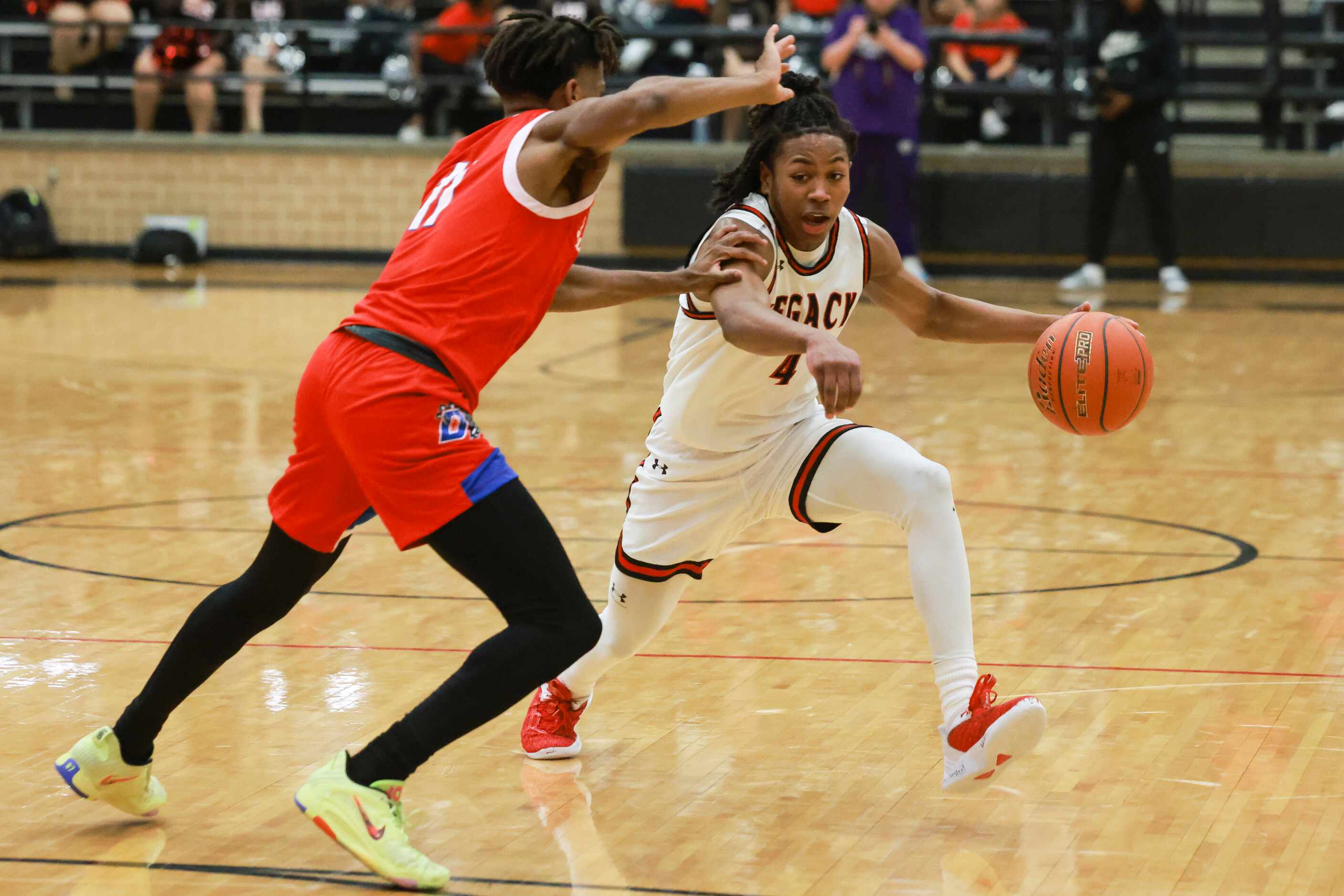 Mansfield Legacy High School’s Amir McMillian (4) dribbles around Duncanville High School’s...