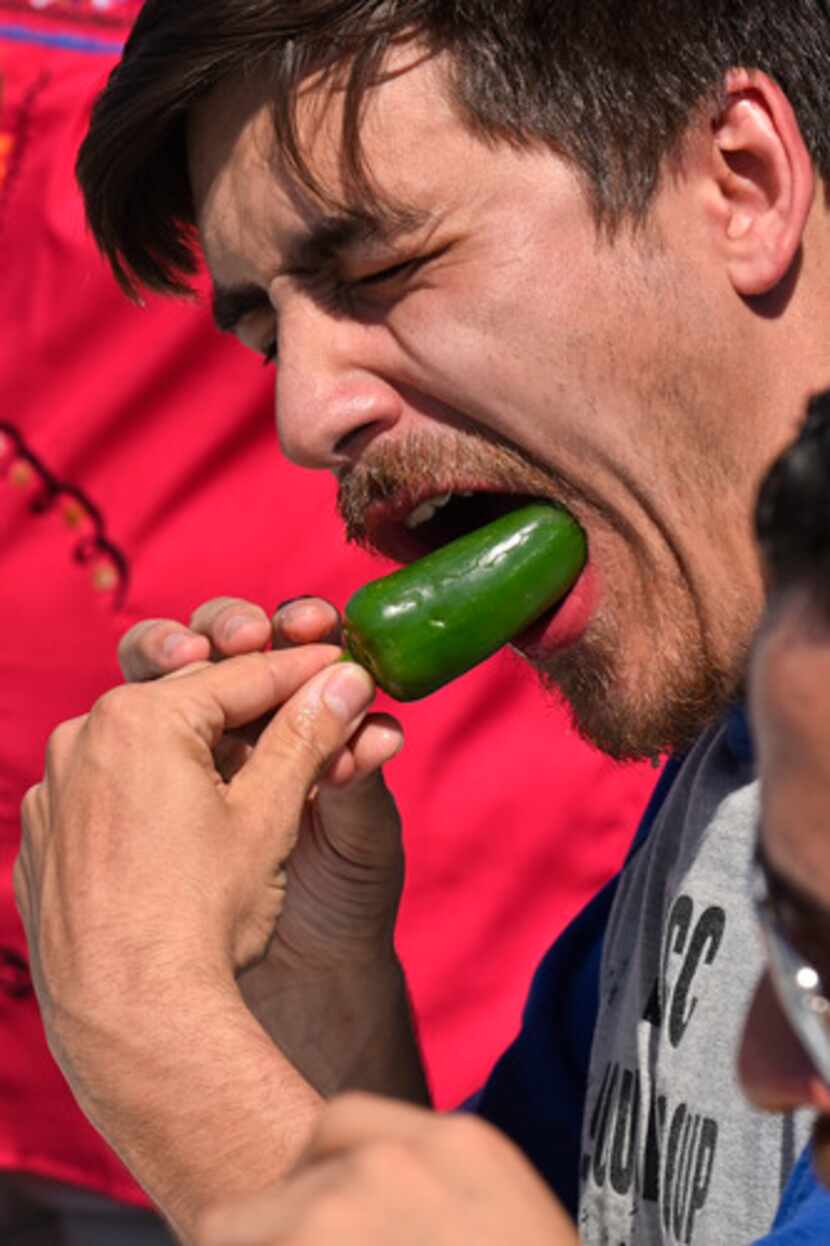 Mark Hinojosa muestra su técnica para comer jalapeños durante el concurso en festejos del...