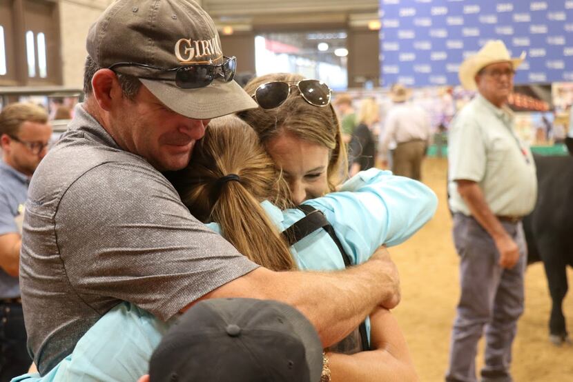 A family of three share a hug at the State Fair of Texas