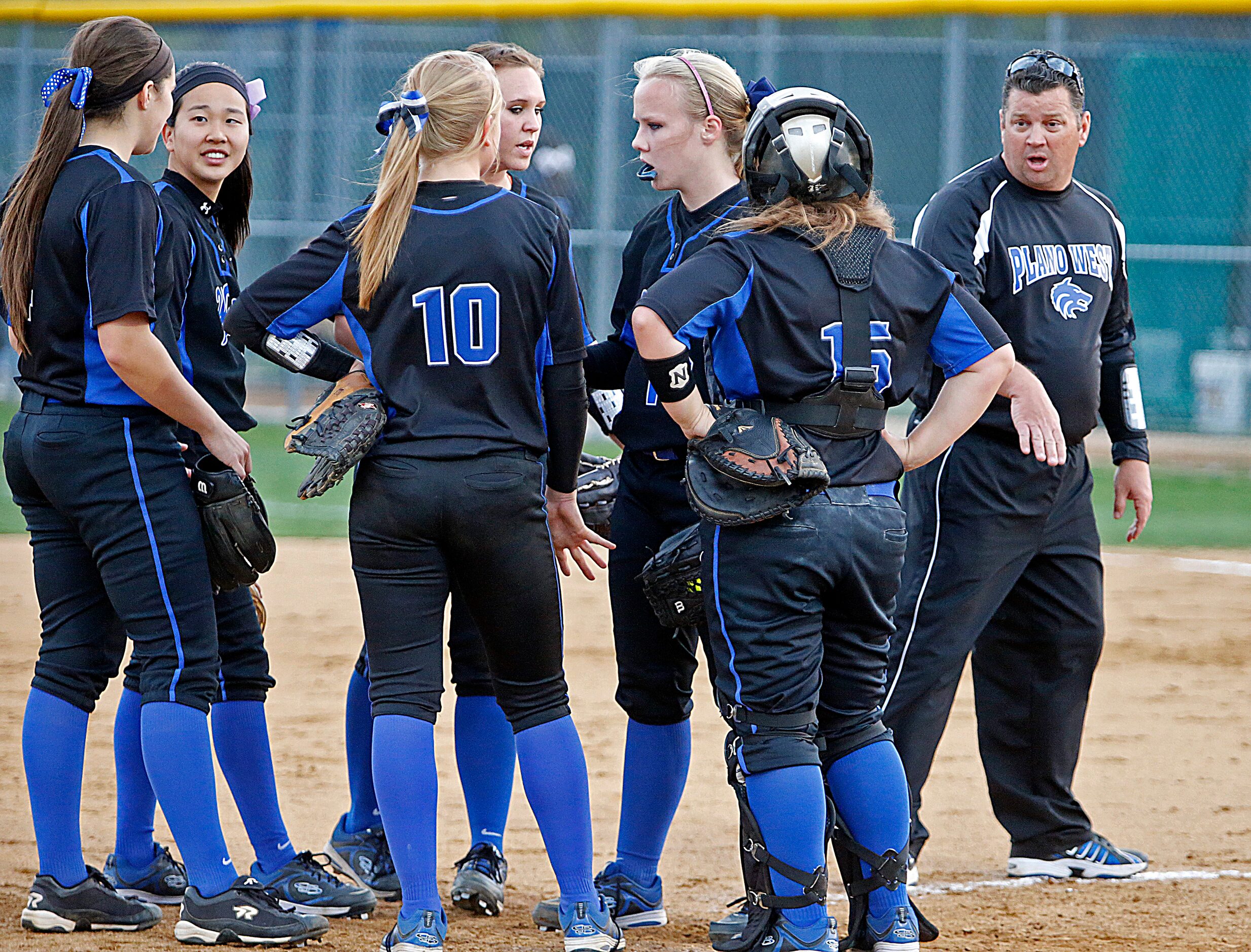 The Plano West High School varsity softball coach Mike Ledsome (right) meets with his...