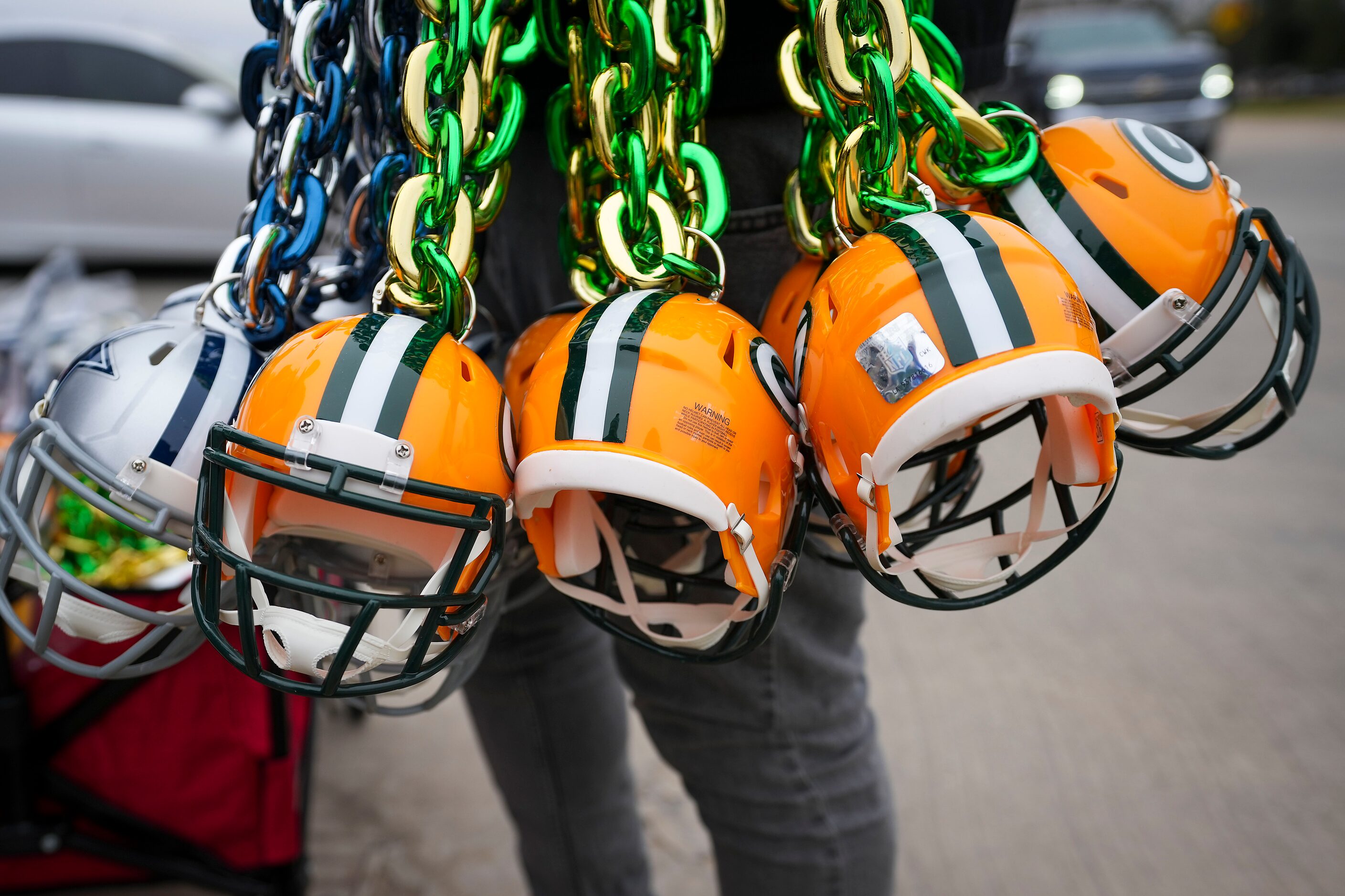 A man sells Dallas Cowboys and Green Bay Packers items outside the stadium before an NFL...