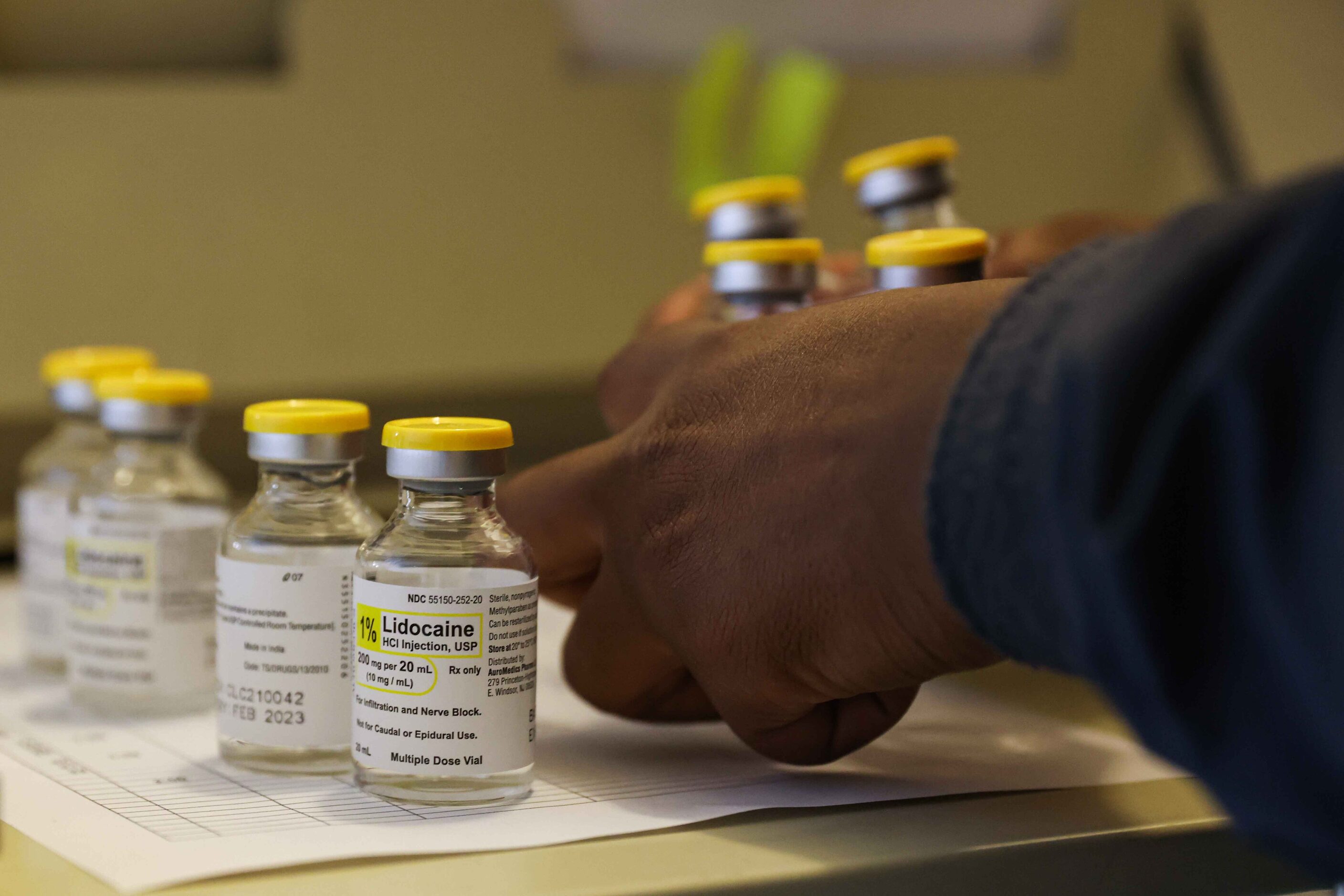 Medical assistant Symone Johnson prepares vials of lidocaine for patients who will be seen...