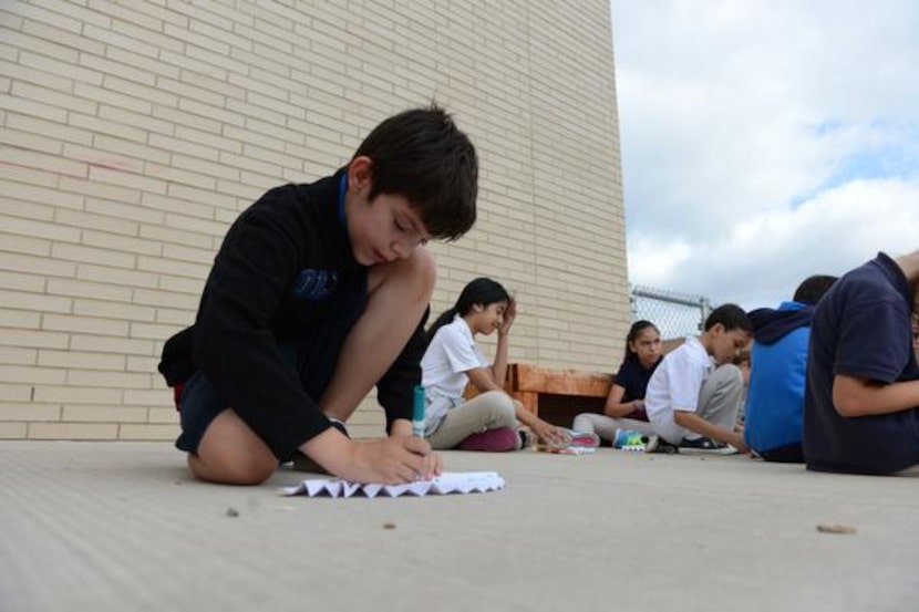 
Alex Ortiz colors a paper fan during the Chinese Dragon Boat Festival at R.E. Good...