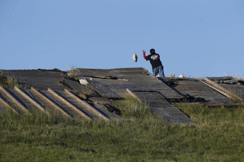 
Workers threw sandbags and placed tarps to prevent further erosion of the Lewisville Lake...
