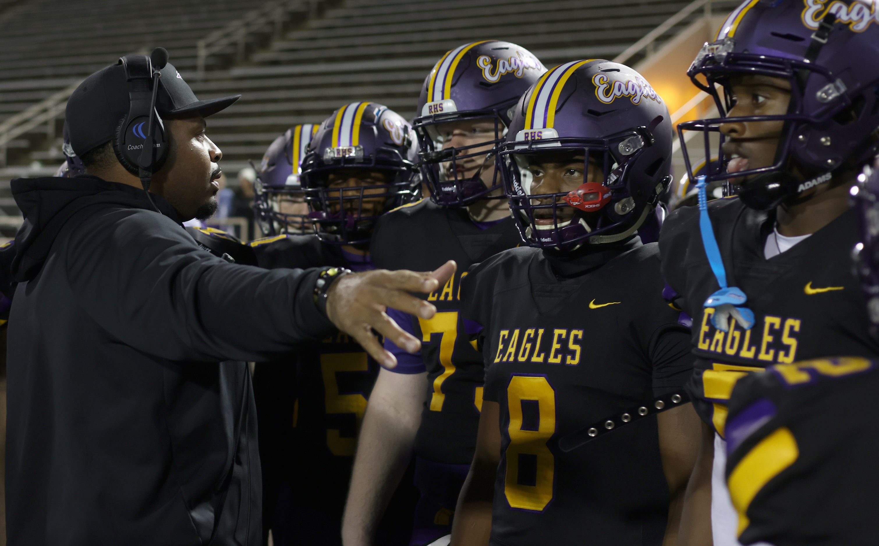 Richardson head coach Kendrick Holloway, left, shares some words with a group of his players...