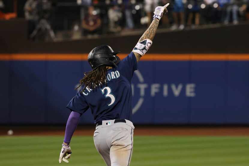 Seattle Mariners' JP Crawford celebrates as he rounds the bases after hitting a home run...