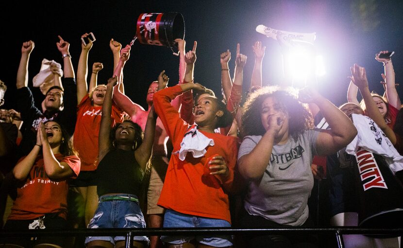 Euless Trinity fans celebrate a touchdown putting them ahead 21-20 during the fourth quarter...