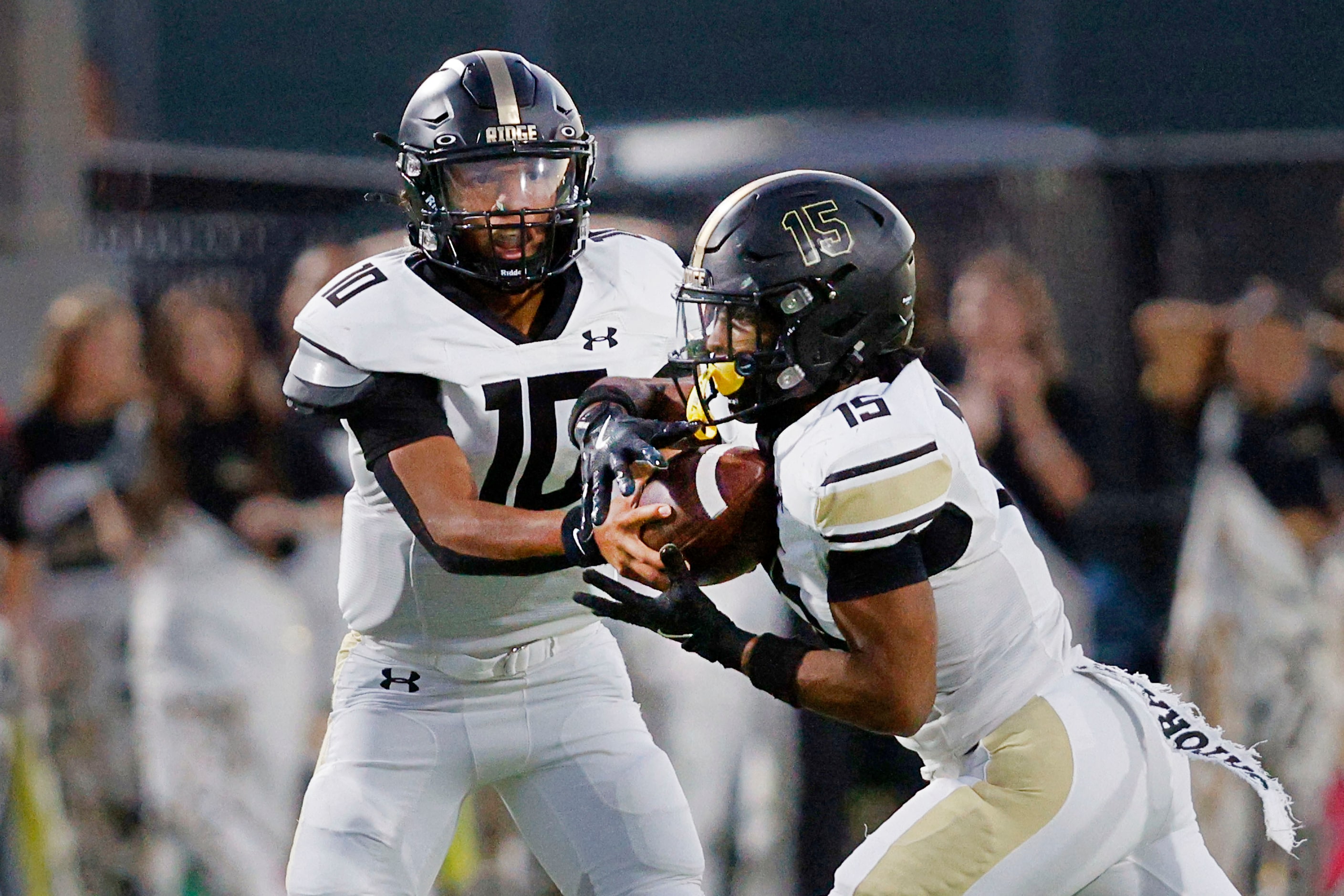 Fossil Ridge's quarterback Malaki Lockhart (10) hands off to Fossil Ridge's Draylon Galloway...