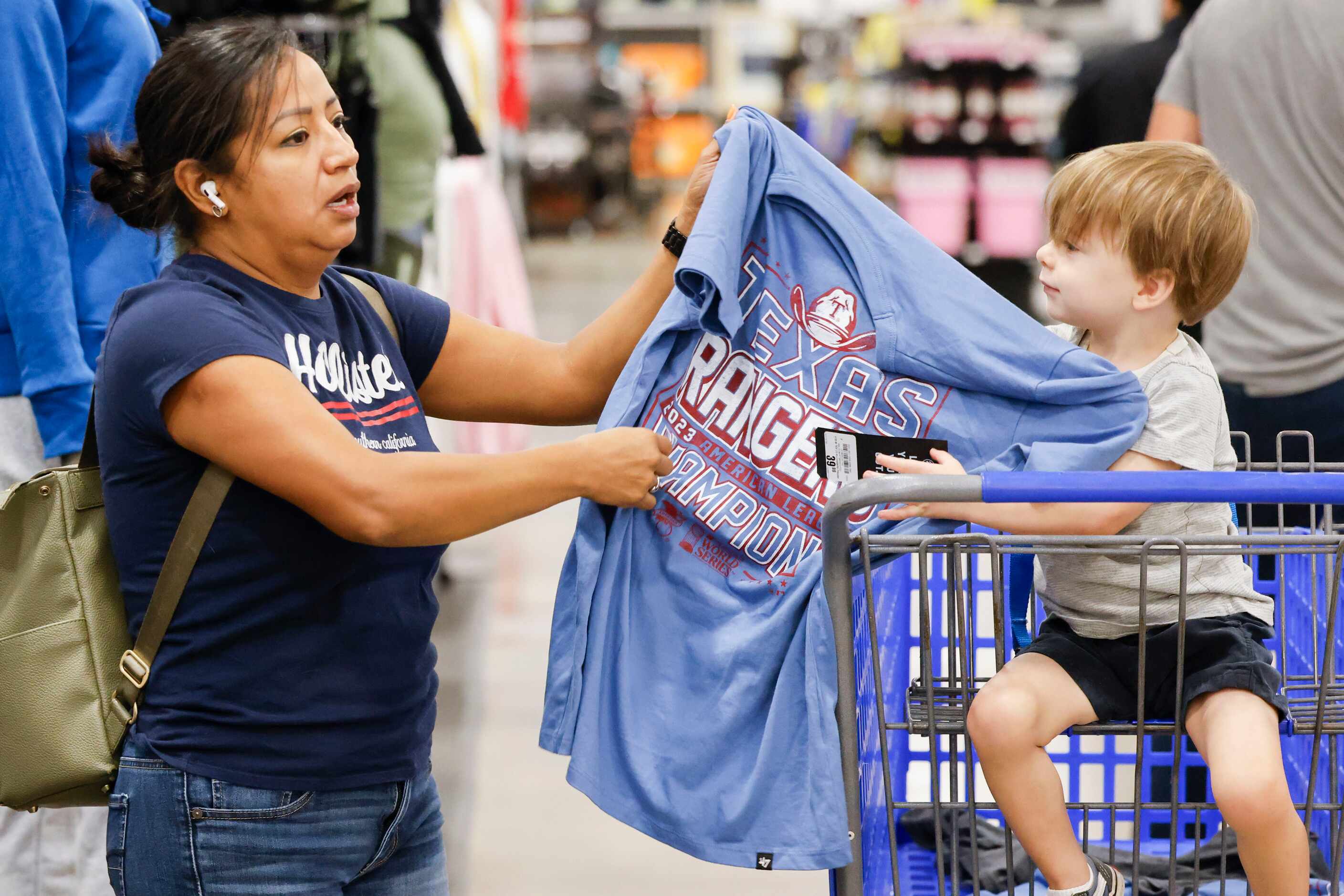 Maria Pecina hands over a Texas Rangers shirt to Shep O’Harra as they shop around Academy...