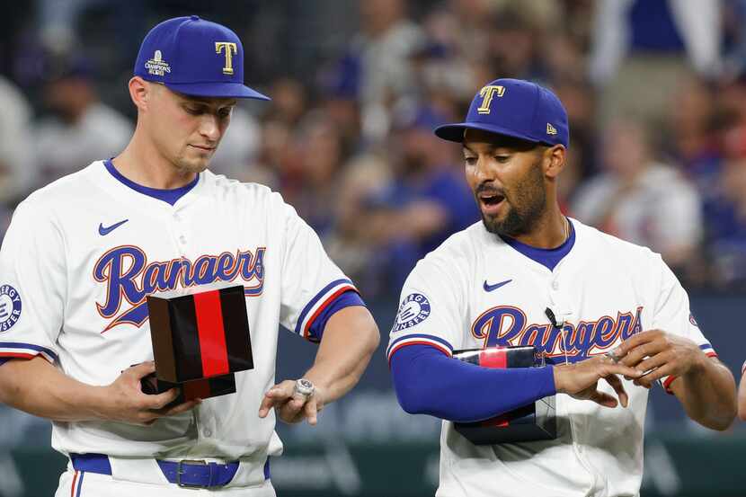 Texas Rangers second baseman Marcus Semien (right) reacts as shortstop Corey Seager tries on...