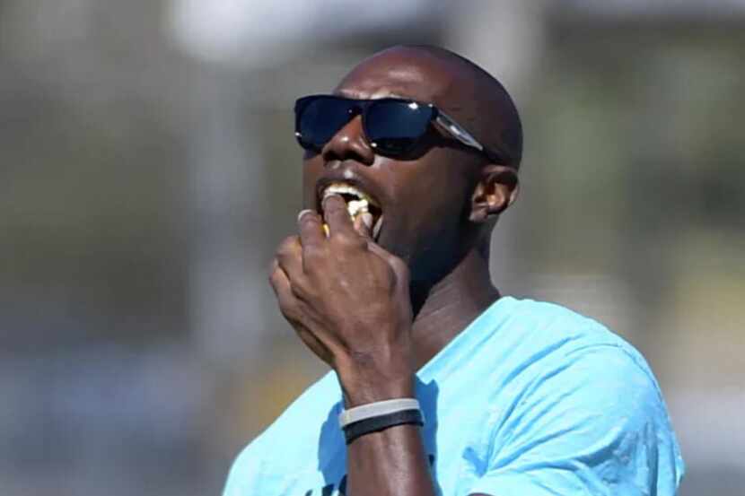 Former Dallas Cowboys player Terrell Owens eats popcorn during their afternoon practice in...