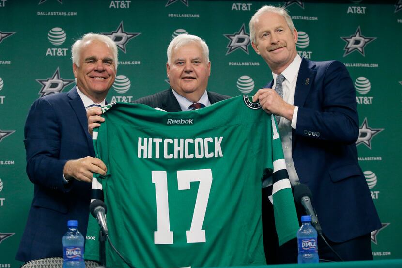 Dallas Stars newly hired NHL hockey team head coach Ken Hitchcock, center, poses for photos...