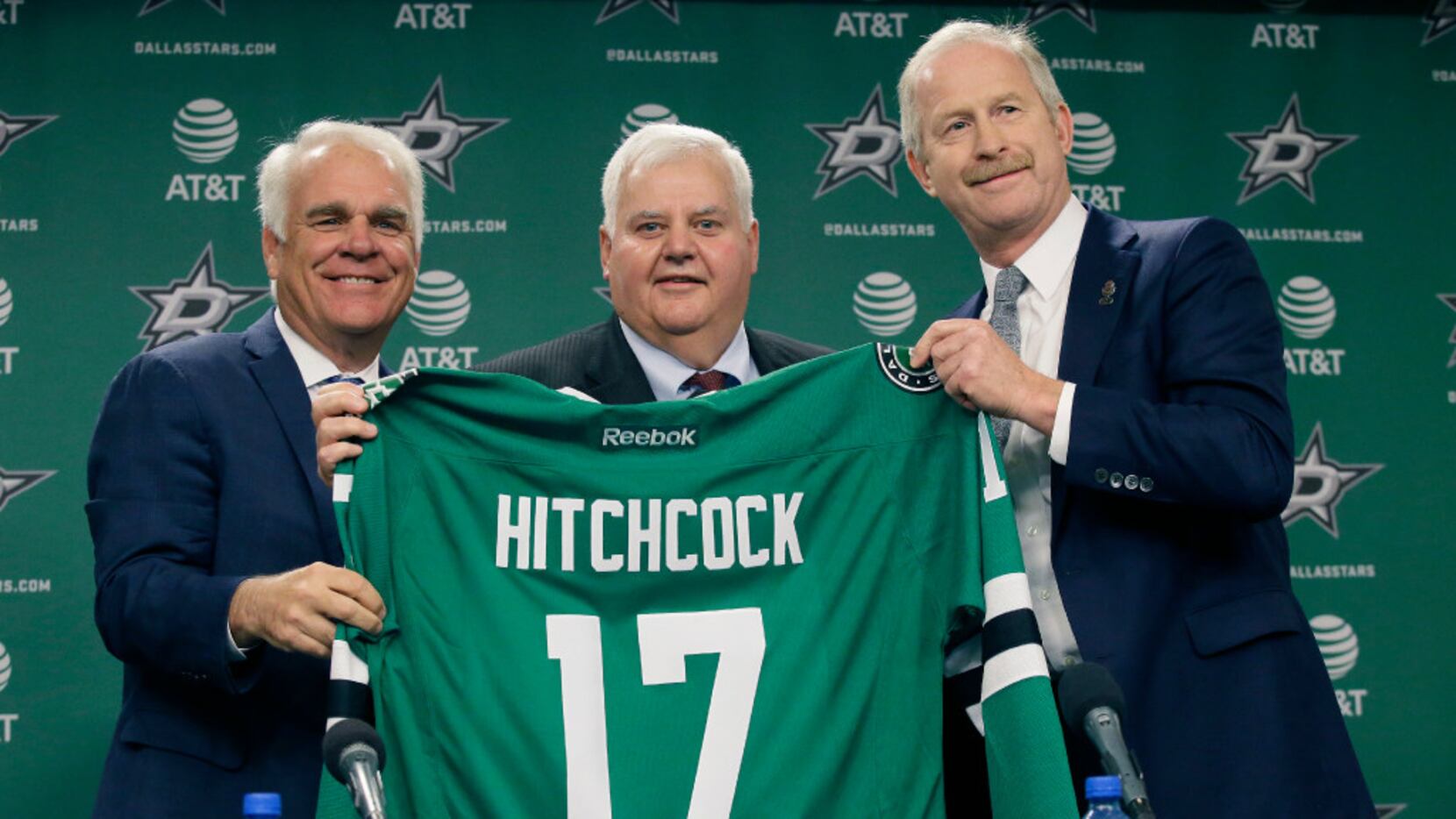Dallas Stars newly hired NHL hockey team head coach Ken Hitchcock, center, poses for photos...