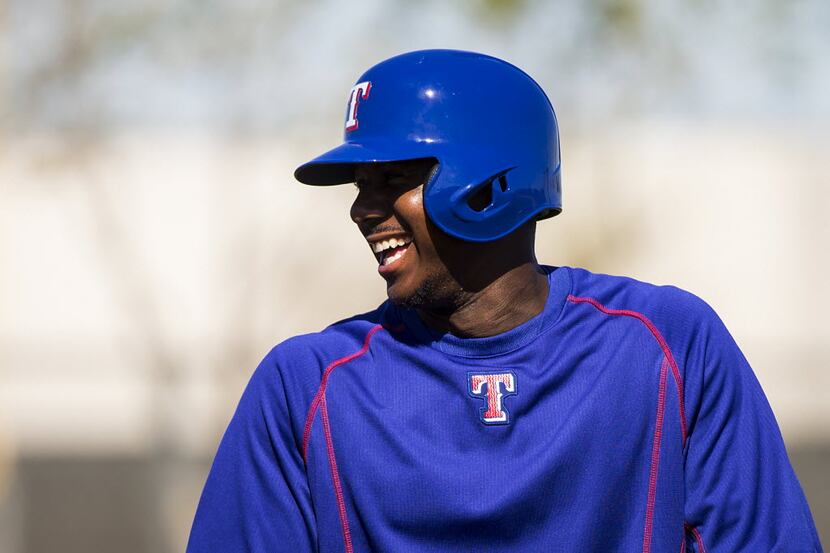 Texas Rangers oufielder Lewis Brinson laughs while participating in a drill during a spring...