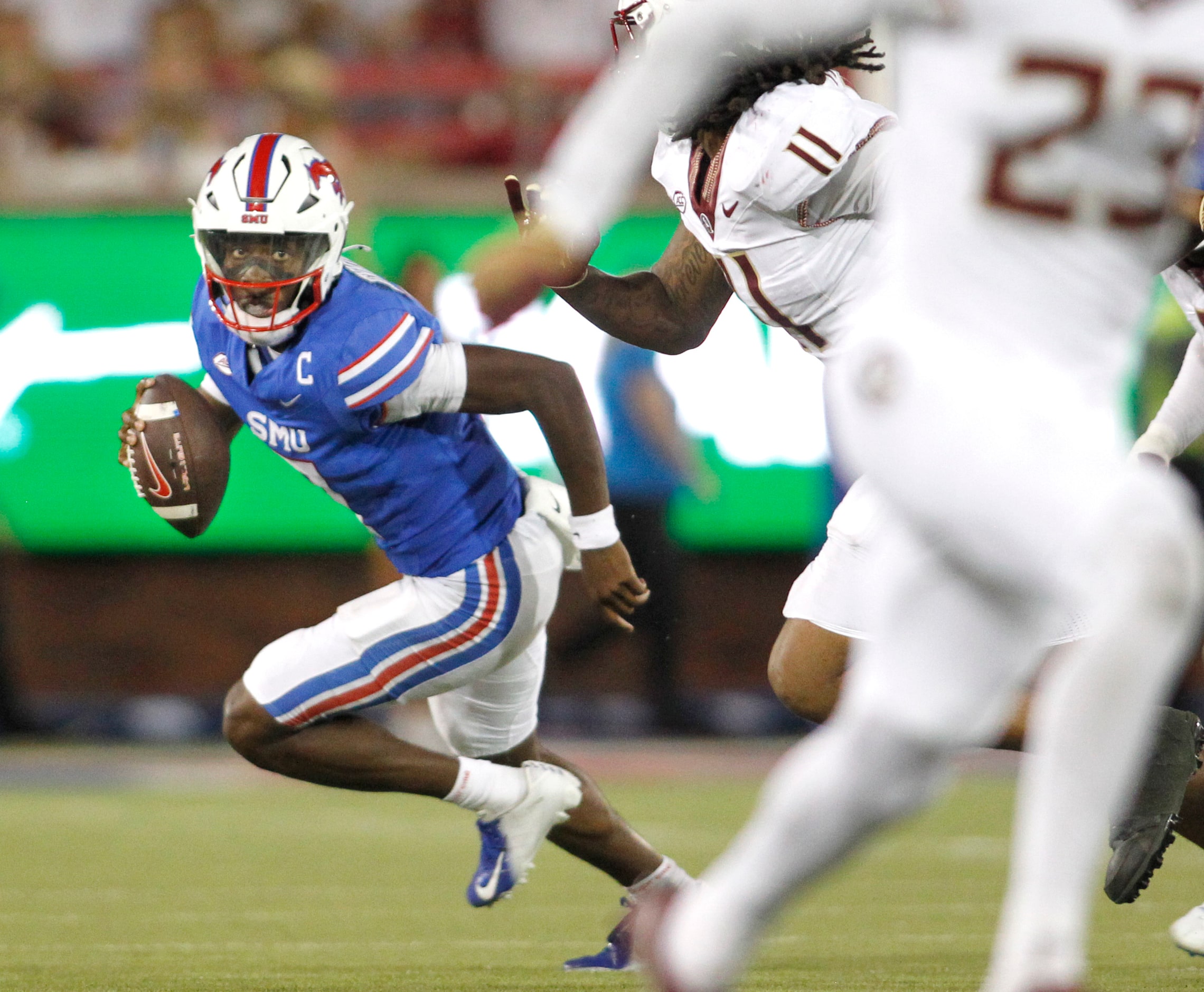 SMU Mustangs quarterback Kevin Jennings (7) looks for room to run as he rolls out of the...