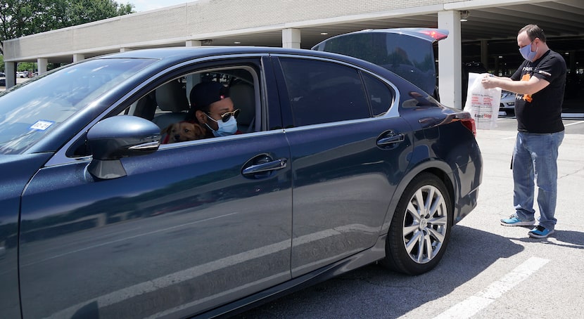 A GameStop employee delivers  a package to Jermaine Murray outside NorthPark Center on Friday.