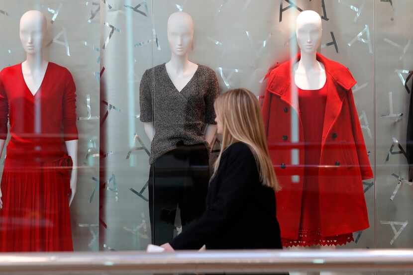 A woman walks by mannequins at the Cherry Creek Mall in Denver on Christmas Eve