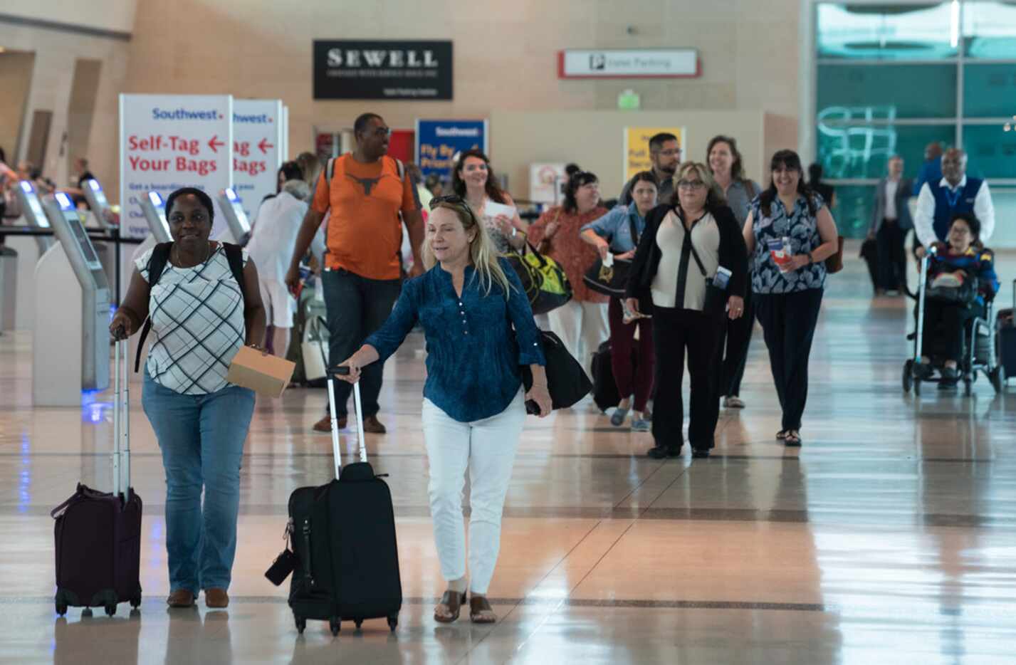 Airline passengers walk through the ticketing area as they walk to the security check-in at...