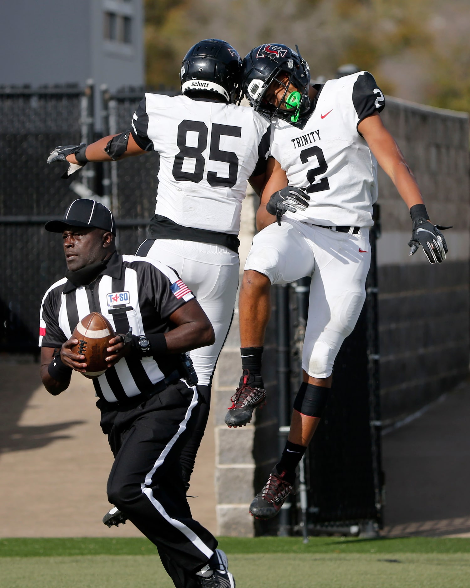 Euless Trinity running back Ollie Jordon (2) celebrates with Xzavior Kautai (85) after...