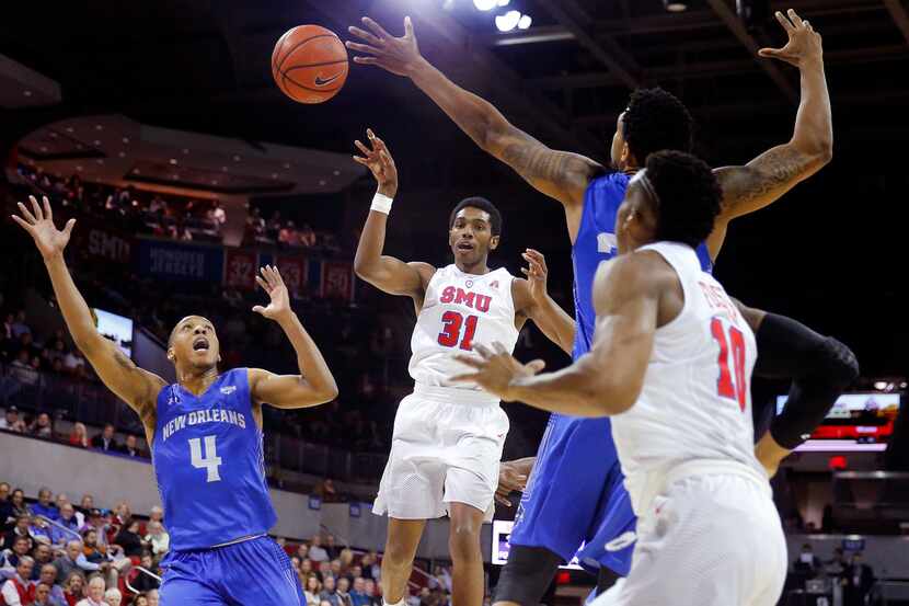 Southern Methodist Mustangs guard Jimmy Whitt (31) passes the ball off to guard Jarrey...