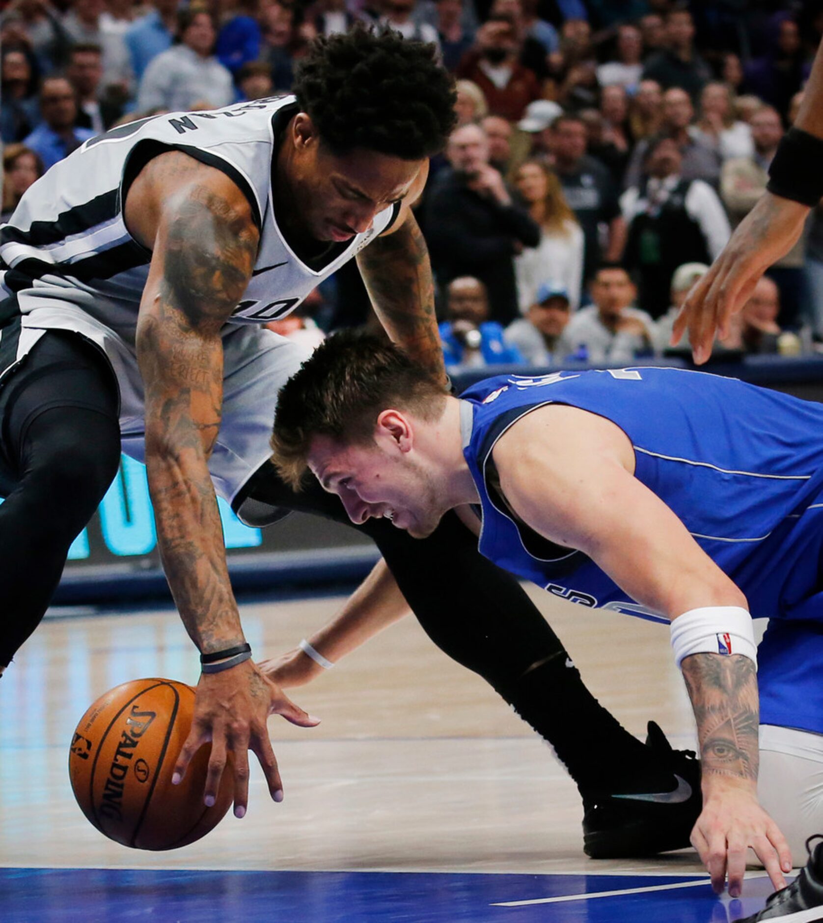 Dallas Mavericks forward Luka Doncic (77) battles for a loose ball against San Antonio Spurs...