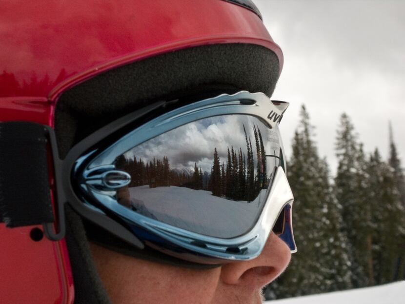 The lofty peaks of the San Juan Mountains reflect from a skier's goggles at the Purgatory...