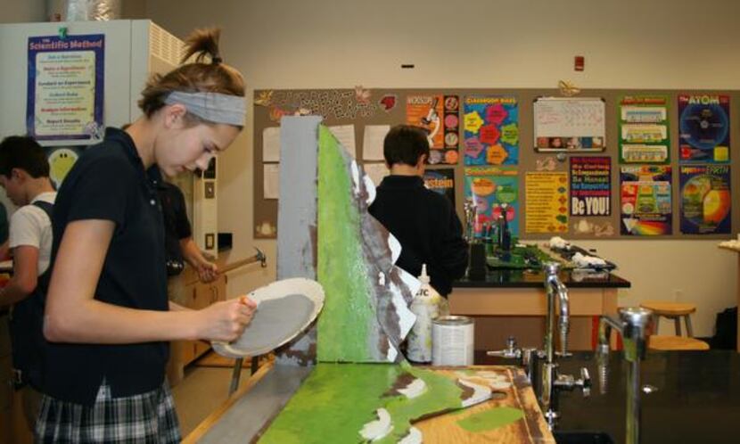 
Virginia Addison paints part of the backdrop for Traverse-City during a seventh-grade...