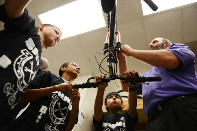 
Sixth-grade Social Studies teacher Steven Smith helps students (from left) Patrick...