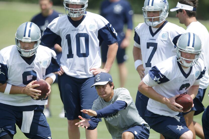 Dallas Cowboys quarterbacks Tony Romo (9) and Brandon Weeden (3) take a snap with...