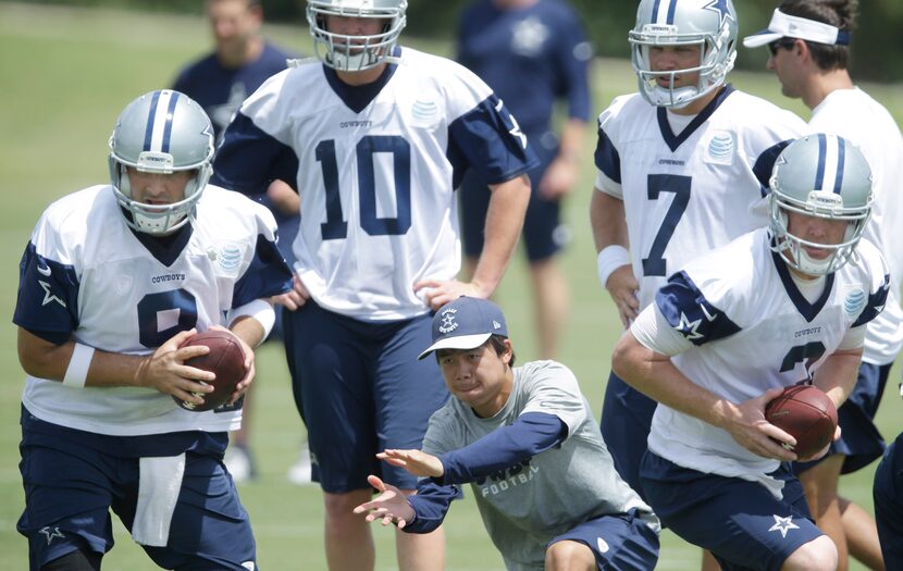 Dallas Cowboys quarterbacks Tony Romo (9) and Brandon Weeden (3) take a snap with...