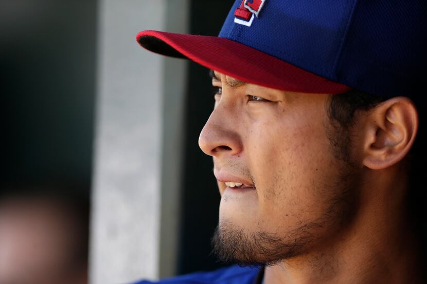 Texas Rangers starting pitcher Yu Darvish, of Japan, watches from the dugout as the Rangers...