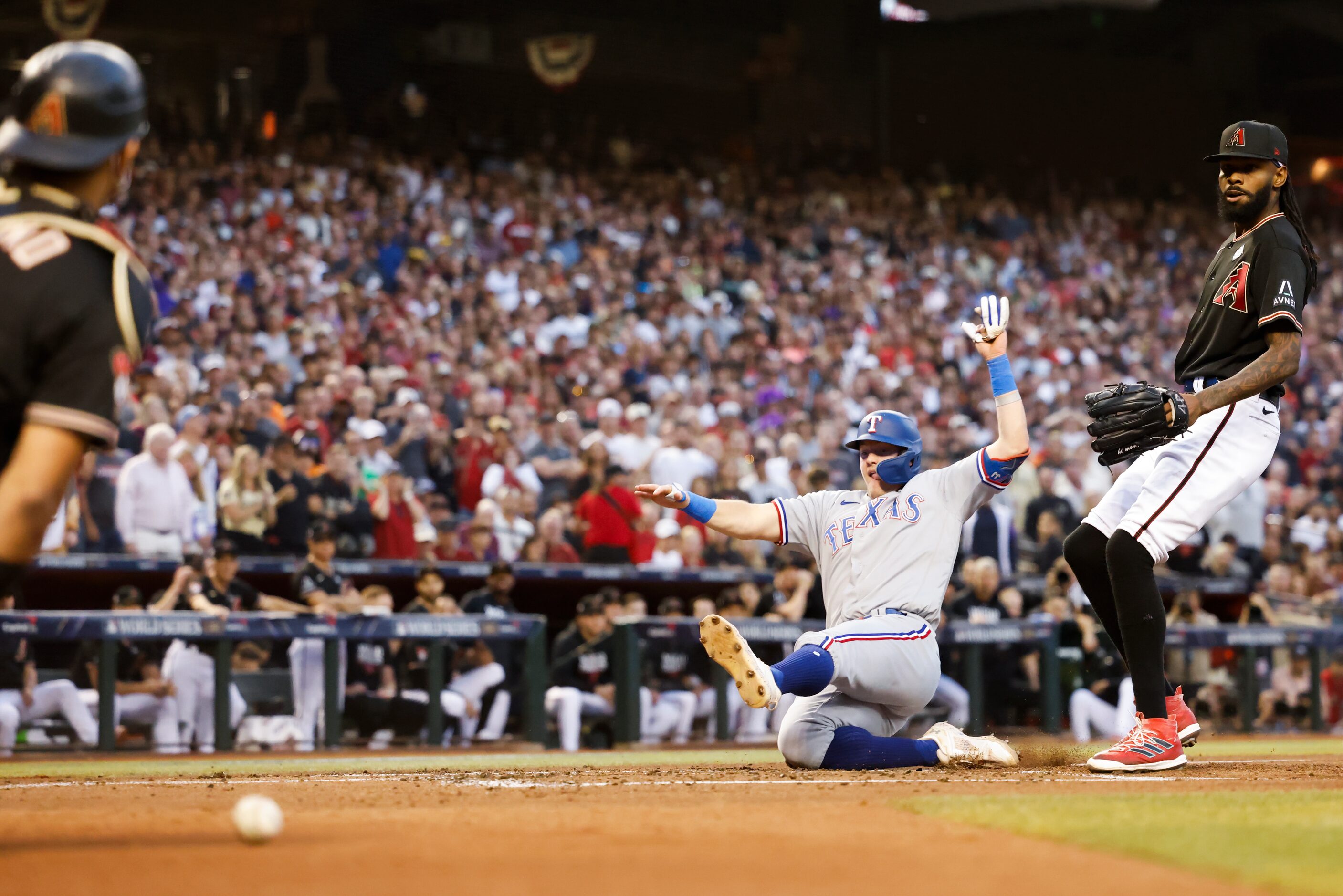 Texas Rangers’ Josh Jung scores on a wild pitch by Arizona Diamondbacks pitcher Miguel...