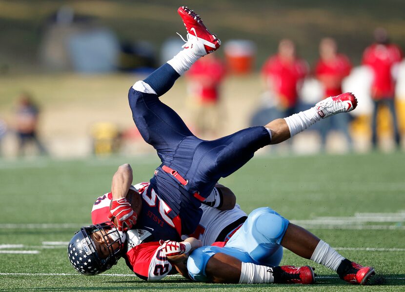 Allen's Marcus Ward (20) is tackled by Skyline's Rodrick Moore (9) during the first half of...