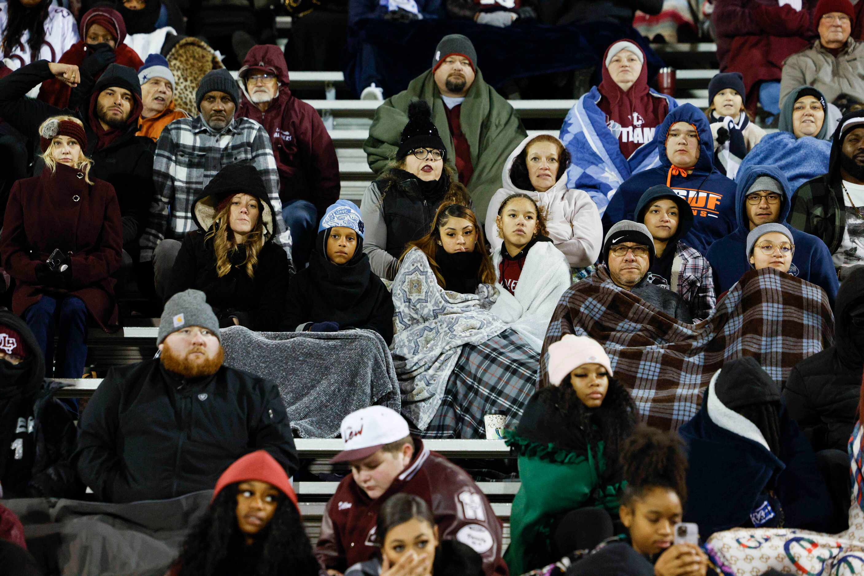 Lewisville fans try to stay warm with coats and blankets as temperatures dipped into the low...